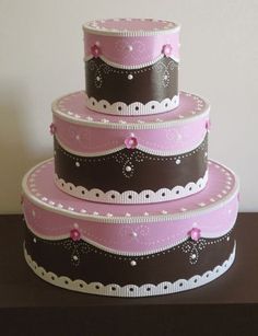 a three tiered cake with pink and brown decorations