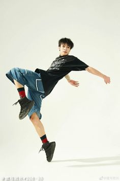 a young man is jumping in the air with his leg up and one hand on his hip