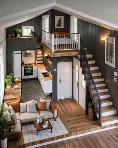 an aerial view of a living room and kitchen in a house with wood flooring