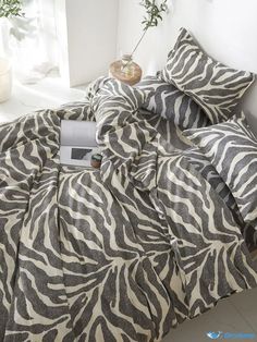 a zebra print comforter set on a bed in a room with white walls and flooring