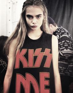 a woman with long hair wearing a shirt that says kiss me