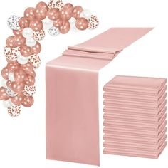 a pink table runner with rose gold and white balloons on it next to a stack of napkins