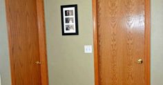 two wooden doors are open in a room with carpeted flooring and framed pictures on the wall