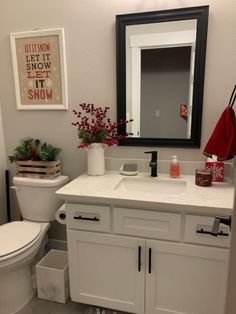 a bathroom with a toilet, sink, mirror and other items on the counter top