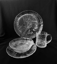 three glass plates and two cups on a black background