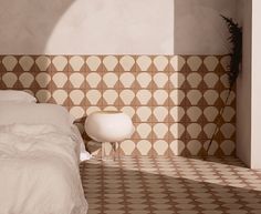 a white bed sitting in a bedroom next to a wall with geometric designs on it