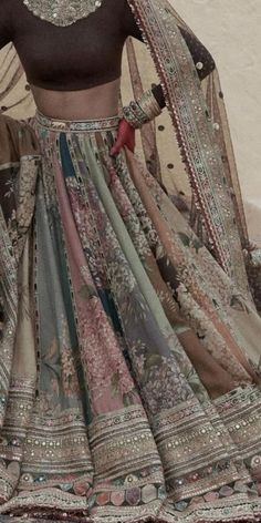 a woman in a bridal outfit standing next to a wall with her hands on her hips