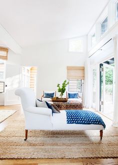 a living room filled with furniture and lots of windows