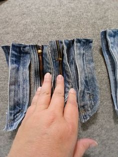 someone is trying to sew the zippers on their jean pants, which have been folded in half