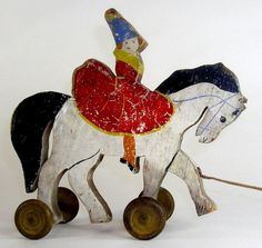 a wooden toy horse with a man riding on it's back