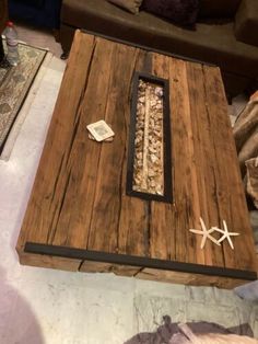 a coffee table made out of wood with shells and starfish on the bottom shelf