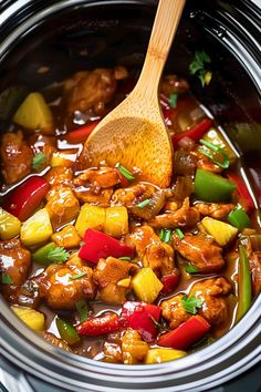 a wooden spoon in a crock pot filled with chicken and pineapple stir fry