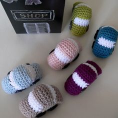 four crocheted slippers sitting on top of a table next to a box