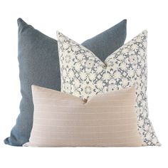 three pillows with different patterns on them, one in blue and the other in beige