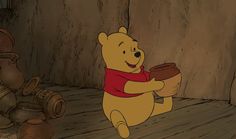 winnie the pooh is holding a pot in front of an old wooden wall with writing on it