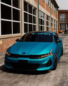 a blue car parked in front of a building