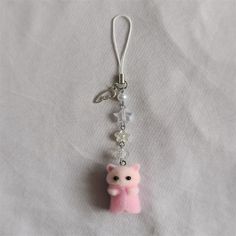 a key chain with a small pink bear on it