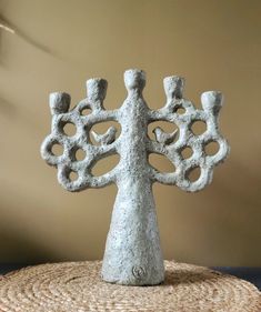 a stone tree sculpture sitting on top of a straw hat