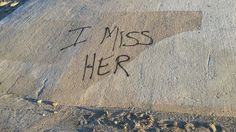 the word i miss her written in sand