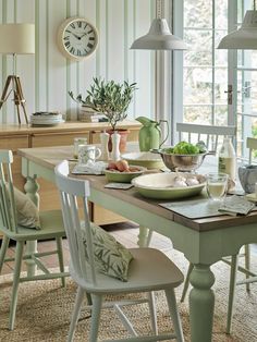 a dining room table with green chairs and plates on it