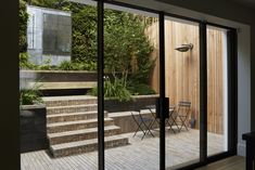 an open patio with steps leading up to the back door and outside dining room area