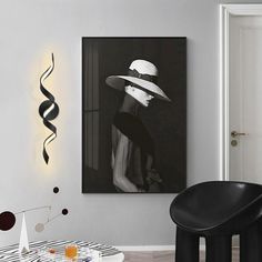 a black and white photo hanging on the wall in a living room next to a chair