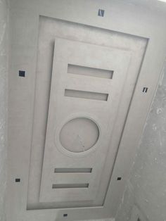 the ceiling in this bathroom is made out of concrete and has a clock on it