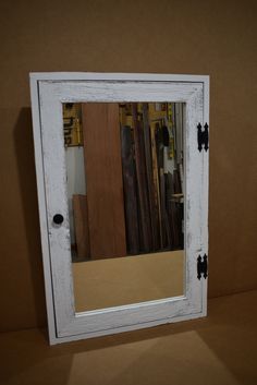 a mirror that is sitting on top of a shelf in front of a brown wall