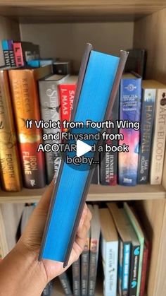 a person holding up a blue book in front of bookshelves with text that reads if violet from fourth wing and river from ago air at a book