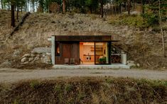 a small house built into the side of a hill with doors open on both sides