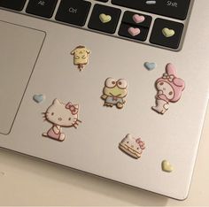 an open laptop computer with hello kitty stickers on the keyboard and mouse pad next to it