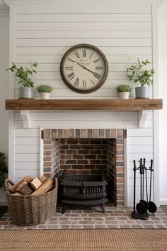 a fireplace with a clock above it and some potted plants on the mantel