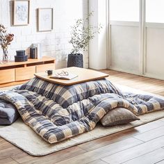 a living room with wooden floors and white brick walls is furnished with an overstuffed sofa