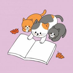 three cats sitting on top of an open book with leaves around them and one cat laying down