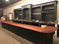 a large wooden counter sitting in the middle of a room with lots of cabinets on it