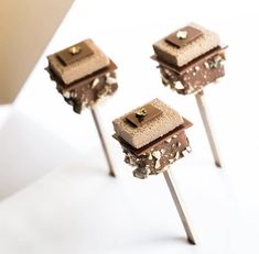 three chocolate cake pops sitting on top of each other in front of a white background