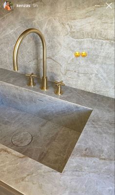 a bathroom sink with two faucets on the side and a marble counter top