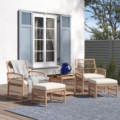 a patio with chairs, tables and a blue vase on the side of the house