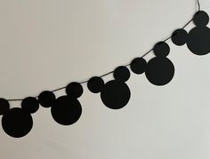 a black mickey mouse party banner hanging from a string with paper circles attached to it