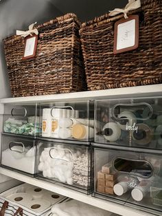 two baskets on top of a shelf filled with toilet paper and other items in bins