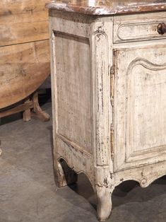 an old white cabinet sitting on top of a floor