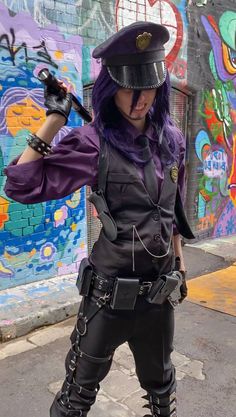 a woman dressed in black and purple posing for the camera