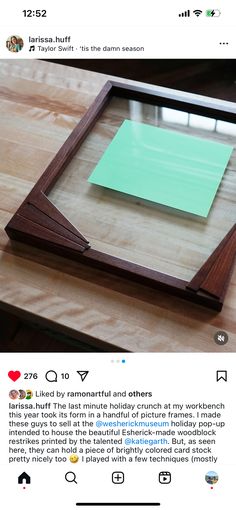 a wooden frame with a green post - it note attached to the side on top of a table