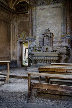 the interior of an old church with pews and stone benches in front of it