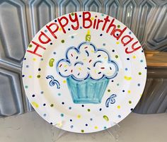 a happy birthday plate with a cupcake design on the front, and confetti sprinkles all over it