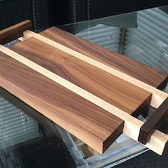 a wooden cutting board sitting on top of a glass table