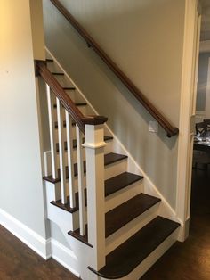 the stairs are made of wood and have white railings on each handrail, along with dark hardwood flooring