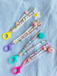 four pairs of scissors sitting on top of a blue cloth next to some plastic beads