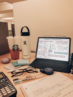 an open laptop computer sitting on top of a desk next to a calculator