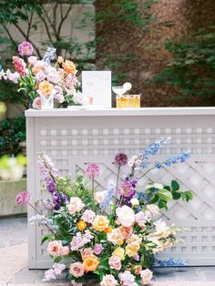 a bunch of flowers that are sitting on a table with some cards in front of it